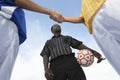 Referee With Opponent Team Players Shaking Hand Against Sky