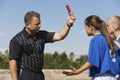 Referee showing red card to girls playing soccer Royalty Free Stock Photo