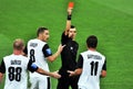 The referee shows a red card to the player