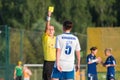 The referee shows a yellow card