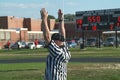 A referee signals a touchdown during a high school football gamr