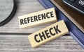 REFERENCE CHECKS. text on wooden blocks on wooden background with office supplies