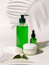 Refillable Cosmetic bottles, jar and tube with green liquid on white, Palm leaf hard shadows