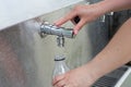 Refilling a plastic water bottle from a tap outdoors at the public park Royalty Free Stock Photo