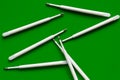 Refills for a ballpoint pen. Plastic rods for a ballpoint pen. Stack of white ink refills on a green Royalty Free Stock Photo