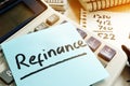 Refinance written on a memo stick and calculator. Royalty Free Stock Photo