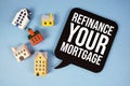 Refinance Your Mortgage text with house models on blue background Royalty Free Stock Photo