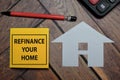 Refinance Your Mortgage write on a sticky note isolated on wooden table