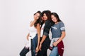 Refined girls in trendy t-shirts posing together in studio and laughing. Indoor photo of fascinating asian lady spending