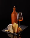 A refined selection of aged cheeses presented on a board, accompanied by a glasses of wine Royalty Free Stock Photo