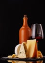 A refined selection of aged cheeses presented on a board, accompanied by a glasses of wine Royalty Free Stock Photo
