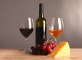 Refined still life of wine, cheese and grapes on wicker tray on wooden table Royalty Free Stock Photo