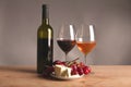 Refined still life of wine, cheese and grapes on wicker tray on wooden table Royalty Free Stock Photo