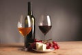 Refined still life of wine, cheese and grapes on wicker tray on wooden table Royalty Free Stock Photo