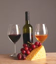 Refined still life of wine, cheese and grapes on wicker tray on wooden table Royalty Free Stock Photo