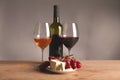 Refined still life of wine, cheese and grapes on wicker tray on wooden table Royalty Free Stock Photo