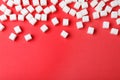 Refined sugar cubes on red background. Space for text Royalty Free Stock Photo