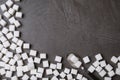 Refined sugar cubes and spoon on black table, top view. Space for text Royalty Free Stock Photo