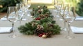 A refined table setup with a cream tablecloth, accented with festive greenery, red berries, and pinecones, making it Royalty Free Stock Photo