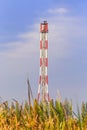 Refinery flare with the grass foreground and blue sky