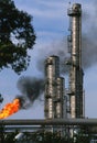 refinery towers seen through dirty black smoke from an onsite flare-burning off excess gas