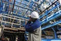 Refinery worker inside giant pipelines constructions