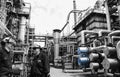 Refinery worker inside giant pipelines constructions Royalty Free Stock Photo