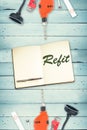 Refit against tools and notepad on wooden background Royalty Free Stock Photo