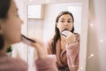 Reflected image of girl powder her chin