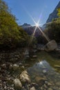 Mirrored sunrise in Vikos gorge, trees, rocks, river, blue sky Royalty Free Stock Photo
