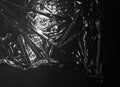 Reflecting Light And Shadow On Creases And Folds In Clear Plastic Foil On Black Background