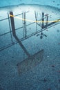 Reflection of basketball board and hoops in a pond on outdoor streetball court