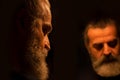 Reflection of bearded man in a dark, with painful expression on his face, alone, sad Royalty Free Stock Photo