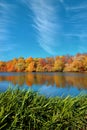 Reflection of a beautiful autumn forest in the river, against the background of a clear blue sky without clouds, with Royalty Free Stock Photo