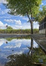 Reflection of beautiful cloudy sky and tree in a puddle on the road. Calm after the storm concepts Royalty Free Stock Photo