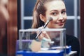 Reflection of a beautiful girl in the mirror doing makeup at the dressing table in the room at home, young woman preparing face, Royalty Free Stock Photo