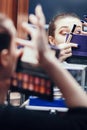 Reflection of a beautiful girl in the mirror doing makeup at the dressing table in the room at home, young woman preparing face, Royalty Free Stock Photo