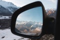 Reflection of a beautiful mountain landscape at sunset in the side mirror of the rear view. Royalty Free Stock Photo