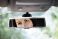 Reflection of a beautiful young woman face in the car rear view mirror. Royalty Free Stock Photo