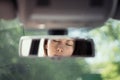 Reflection of a beautiful young woman relaxing with  closed eyes in the car rear view mirror. Royalty Free Stock Photo