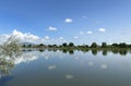 Reflection on Beck Lake in Cody, Wyoming, is seen with blue sky and white cloud dots and Heart Mountain in the background. Royalty Free Stock Photo