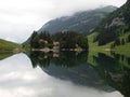 Reflection of Berggasthaus Forelle in alpine lake Seealpsee in Alpstein Appenzell alps Innerrhoden Switzerland