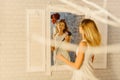 The reflection of the blond teenager drying her hair. Royalty Free Stock Photo