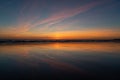 Reflection of blood red sunset on the wet sand on the beach and dark horizon line Royalty Free Stock Photo