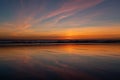 Reflection of blood red sunset on the wet sand on the beach and dark horizon line Royalty Free Stock Photo