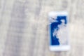 Reflection of blue sky with clouds in the phone-smartphone, which lies on a bright wicker table against the background. Blur and Royalty Free Stock Photo