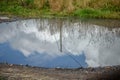 Reflection of the blue sky in a rain puddle Royalty Free Stock Photo