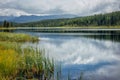 Reflection of blue sky with white clouds in the mirror surface of mountain lake. Beautiful Alpine natural landscape Royalty Free Stock Photo