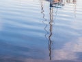 Reflection of a boat mast in the port of Olhao, Algarve region in south of Portugal, at sunset