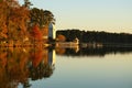 Reflection of a boathouse and fall foliage in a calm lake